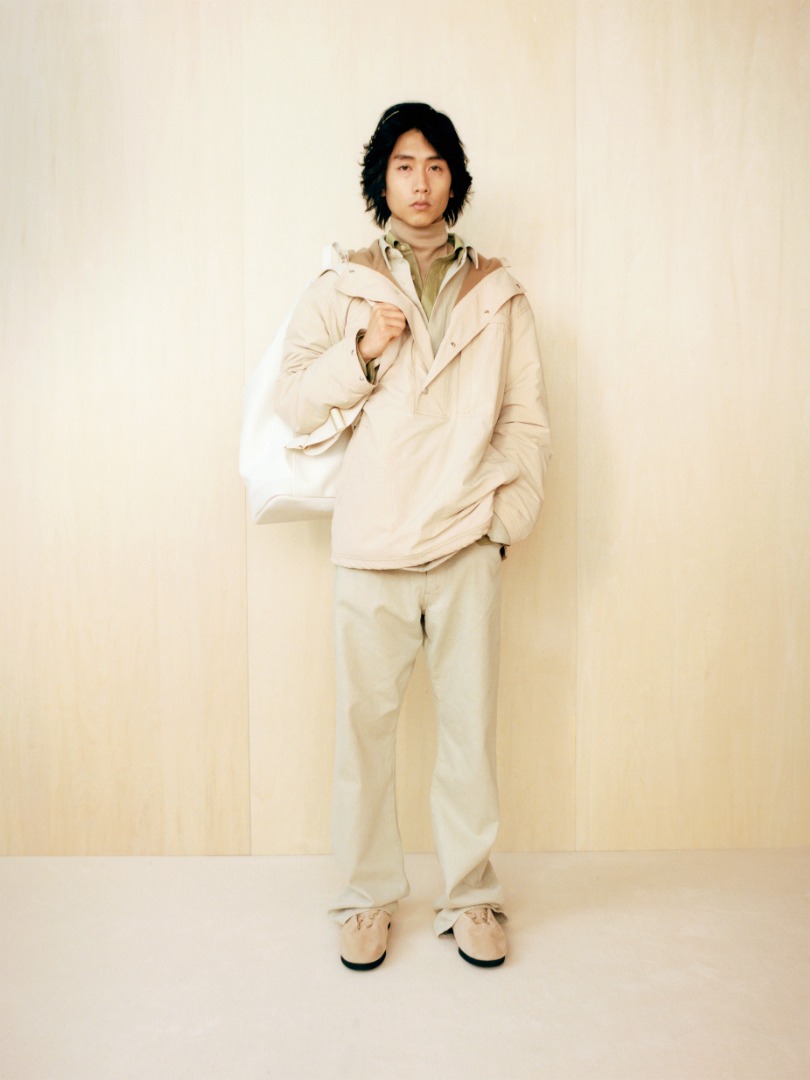 Kai wears Biodegradable Nylon P/O Hooded Blouson in Light Beige, Botanical Dyed Selvedge Denim Pants in Natural Green