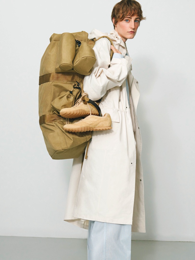 Ines wears High Density Cotton Polyester Cloth Hooded Coat in Ivory, Boston Bag Made By Aeta in Beige, Pouch Set Made By Aeta in Beige
