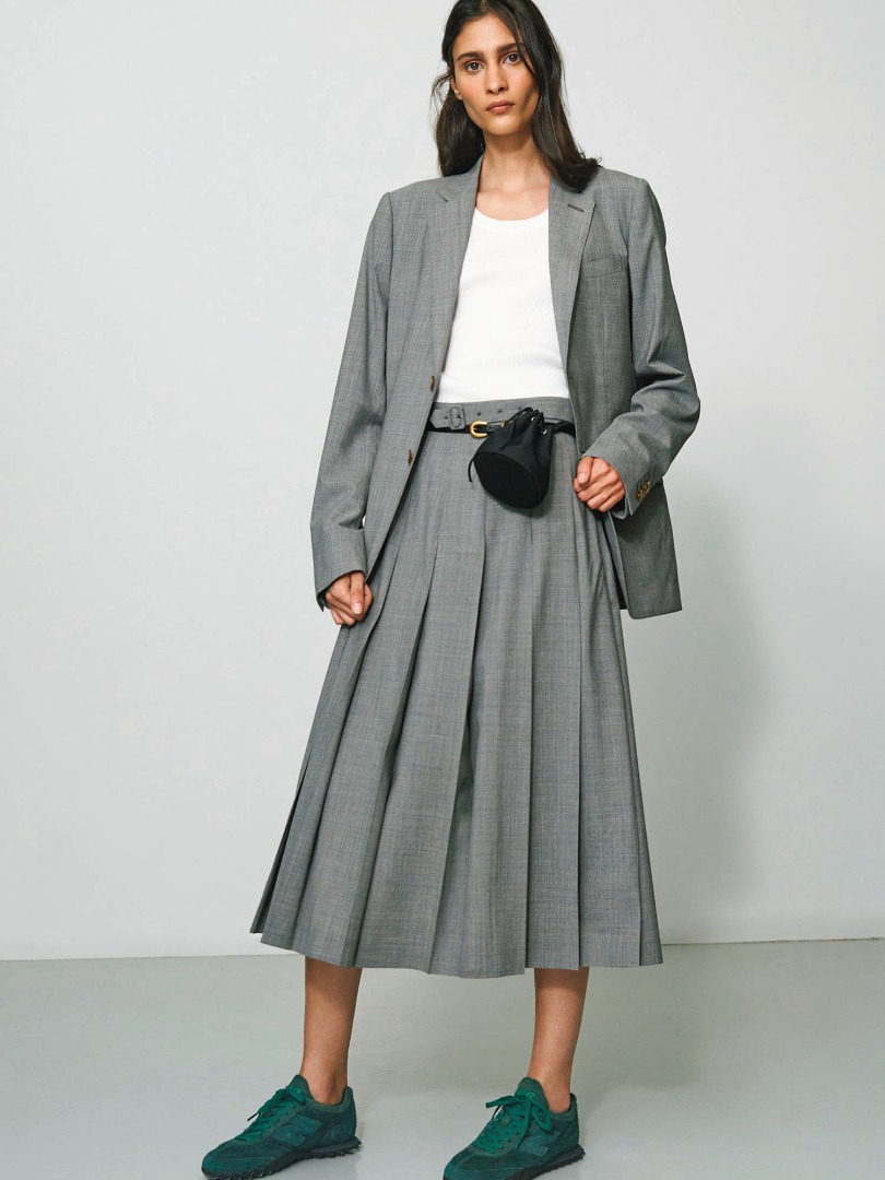 Renda wears Super Fine Tropical Wool Jacket in Top Gray, Super Fine Tropical Wool Pleated Skirt in Top Gray