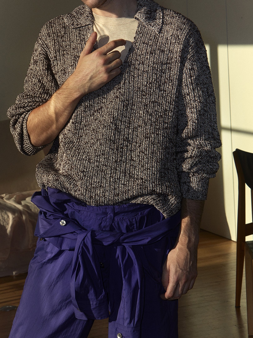 Etienne wears Cotton Slub Mix Top Yarn Rib Knit Skipper Polo in Top Brown, Washed Cotton Nylon Weather Jumpsuit in Purple